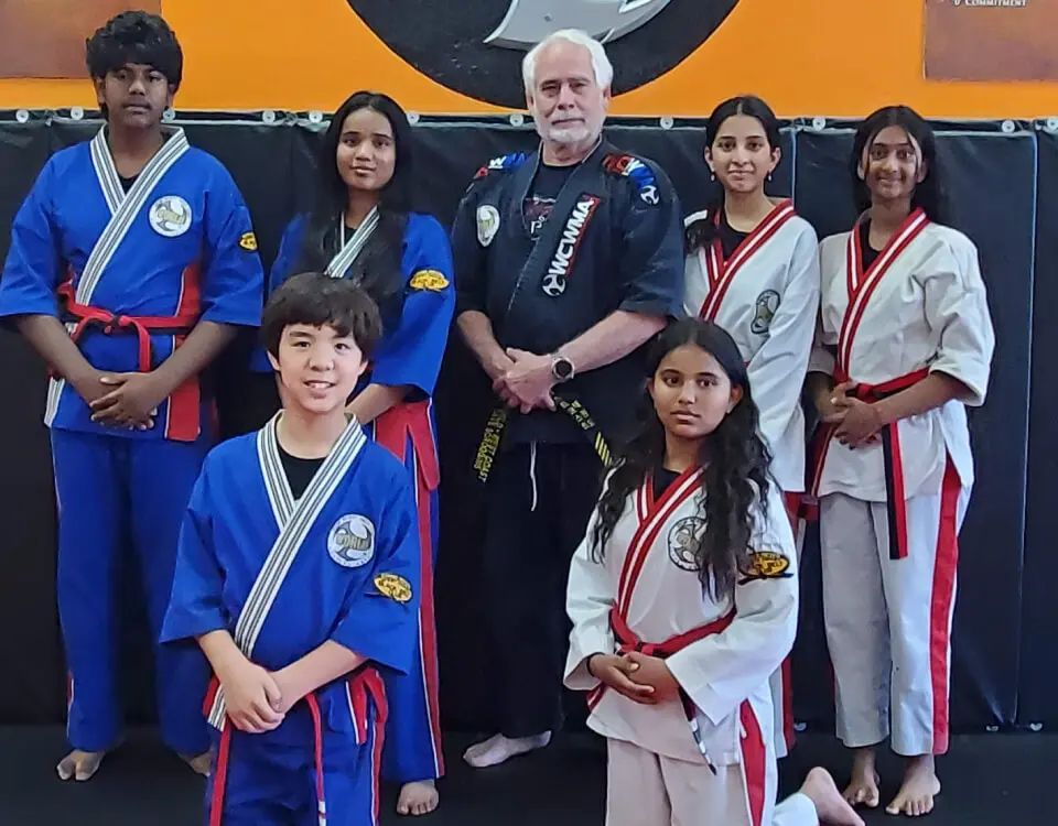 A group of people in martial arts uniforms posing for a picture.