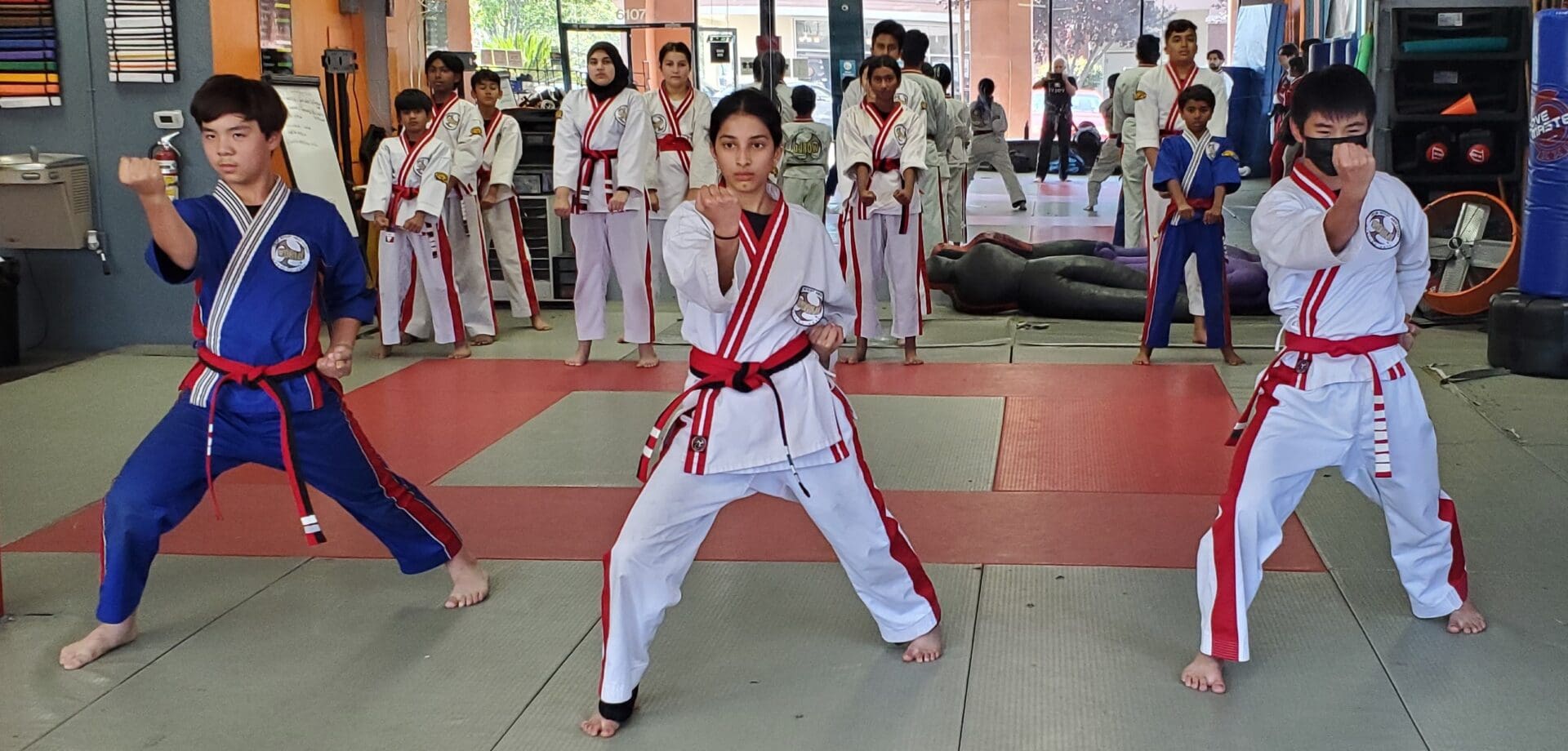 A person in white and red uniform doing a karate move.